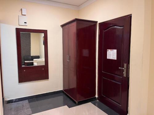 a room with two wooden cabinets and a mirror at Ananya Comfortss in Hospet