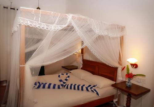 a bedroom with a bed with a canopy at alBum by sEa World in Matara