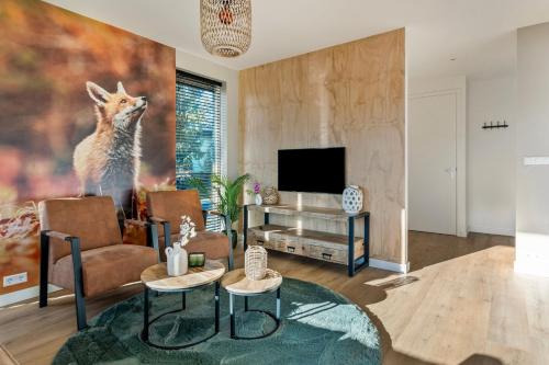 a living room with a fox painting on the wall at 'Lodge de Vos' luxe en vrijstaande lodge bij het Speulder- en Spielderbos in Putten