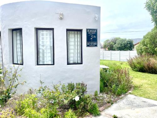 a white house with a sign on the side of it at Kelp Cottage in Gansbaai
