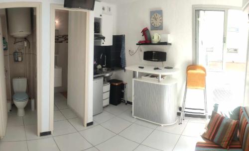 Elle comprend une petite cuisine avec des toilettes et un bureau. dans l'établissement Studio plage, à Canet