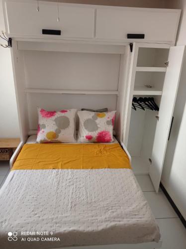 - un lit avec deux oreillers dans une petite chambre dans l'établissement Studio plage, à Canet