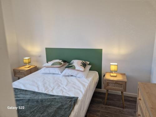 une chambre avec un lit avec deux tables de nuit et deux lampes dans l'établissement Duplex en centre ville, à Villers-Cotterêts