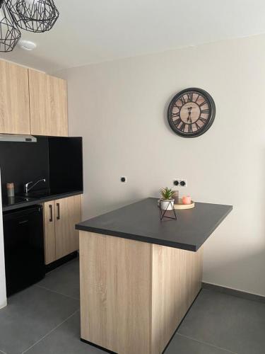 une cuisine avec un comptoir et une horloge au mur dans l'établissement Superbe studio avec terrasse, à La Roche-sur-Foron