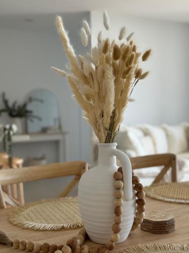 a white vase with flowers in it on a table at Sunshine Coast Paradise in Maroochydore