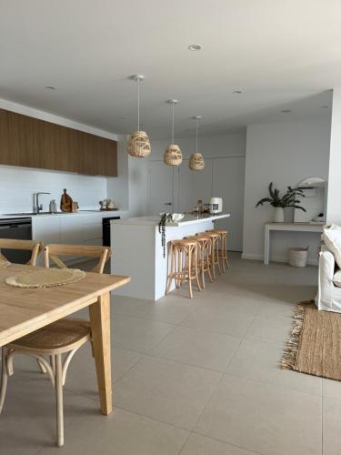 a kitchen and living room with a table and chairs at Sunshine Coast Paradise in Maroochydore