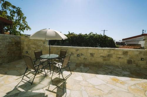 a table with chairs and an umbrella on a patio at Dipaton House in Vasa 1 in Limassol