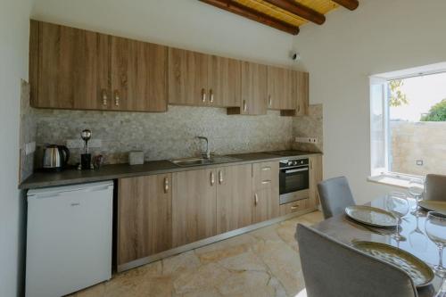 a kitchen with wooden cabinets and a table with a dining room at Dipaton House in Vasa 1 in Limassol