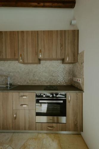 a kitchen with wooden cabinets and a stove top oven at Dipaton House in Vasa 1 in Limassol