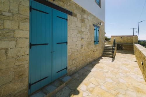 a pair of blue doors on a stone building at Dipaton House in Vasa 1 in Limassol