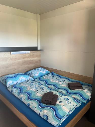 a bed with two pillows on top of it at Mobile homes Tina Pakoštane in Pakoštane