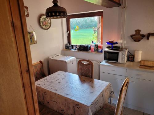 a small kitchen with a table and a window at Ferienwohnung Thomsen in Taarstedt