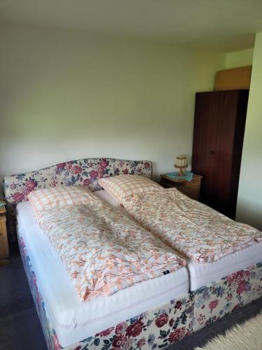 a bed in a bedroom with a floral bedspread at Ferienwohnung Thomsen in Taarstedt