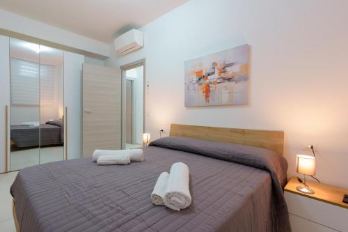 a bedroom with a bed with two towels on it at Casa rossoblu - zona stadio in Bologna
