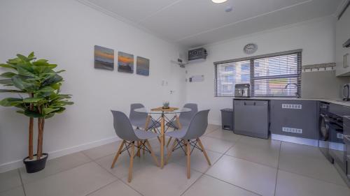 a kitchen and dining room with a table and chairs at Ballito Village Luxury Apartments in Ballito