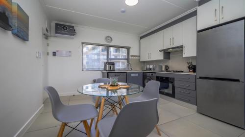 a kitchen with a table and chairs in a kitchen at Ballito Village Luxury Apartments in Ballito
