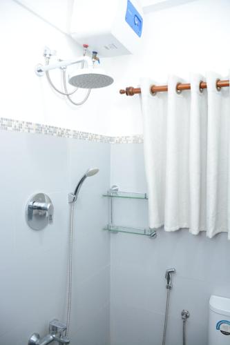 a bathroom with a shower and a shower curtain at Anuradhapura Stay Apartments in Anuradhapura
