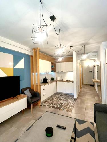 a living room with a couch and a kitchen at Hugo's Apartment in Suceava
