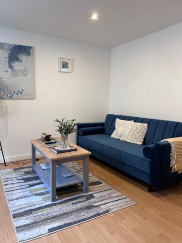 a blue couch in a living room with a table at The Tannery Mews 2 Bedroom Dublex Apartment in York
