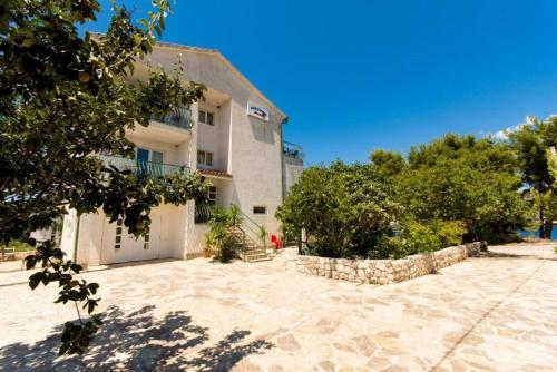 a large white building with a white garage at Apartments Sandra in Okrug Donji