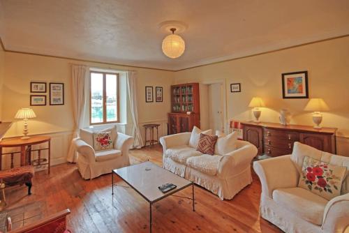 a living room with two couches and a table at Les Hirondelles in Villemain