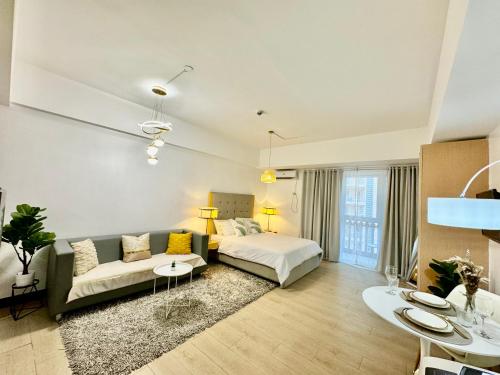 een grote woonkamer met een bed en een bank bij Cozy home Near NAIA & BGC in Manilla
