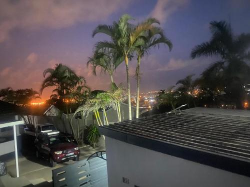 a house with palm trees and a truck on the roof at Fish Eagle Place in Durban
