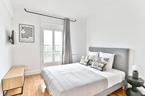 une chambre blanche avec un grand lit et une fenêtre dans l'établissement Studio tout équipé à Montreuil proche Paris - II, à Montreuil