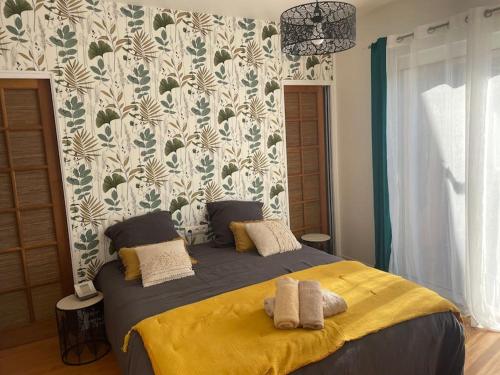 une chambre avec un grand lit avec une couverture jaune dans l'établissement Charmante Maison entre Castres et Lautrec, à Laboulbène