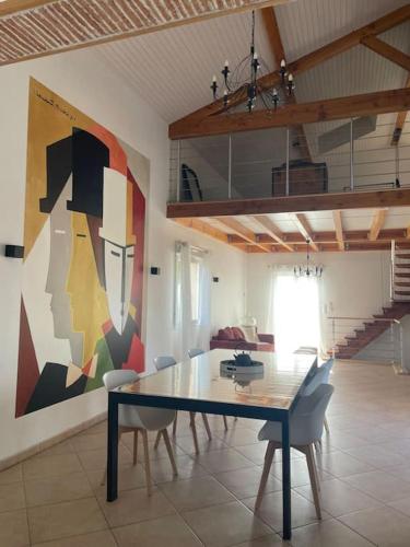 une salle à manger avec une table et des chaises et un tableau dans l'établissement Charmante Maison entre Castres et Lautrec, à Laboulbène