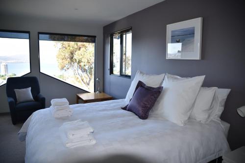 a bedroom with a large bed with towels on it at Studioat10 in Hobart