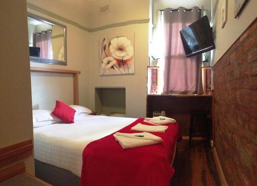 a bedroom with a bed with towels on it at NORD - North Hobart Apartments in Hobart