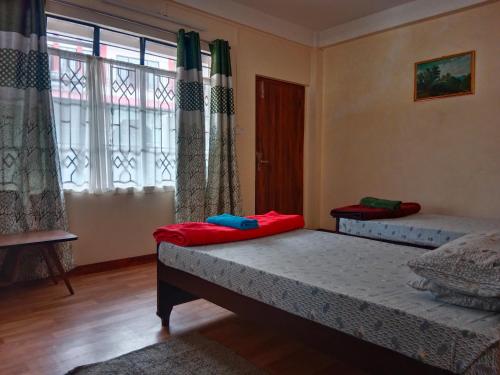 two beds sitting in a room with windows at Cafe Sola bnb in Shillong