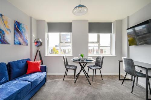 a living room with a blue couch and a table at Marygate by Deuce Hotels Ltd in Wakefield