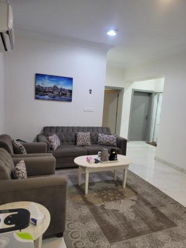 a living room with a couch and a table at المغتره للشقق المخدومه in Ad Dawādimī