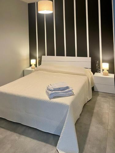 Una cama blanca con dos toallas blancas encima. en Residence Sabry, en Piacenza