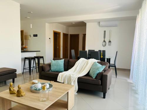 a living room with a couch and a table at Techas Near Beach Apt with Pool in Praia