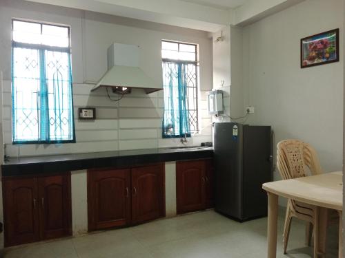 a kitchen with a black refrigerator and a table at Cafe Sola bnb in Shillong