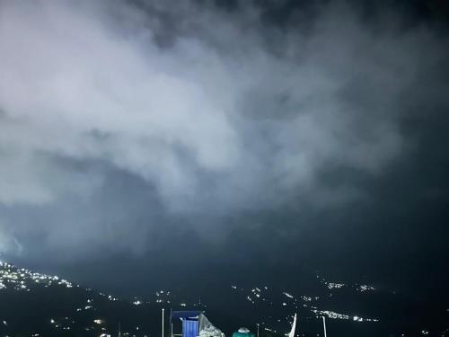 a cloudy sky with a city in the background at Geranium Homestay in Darjeeling