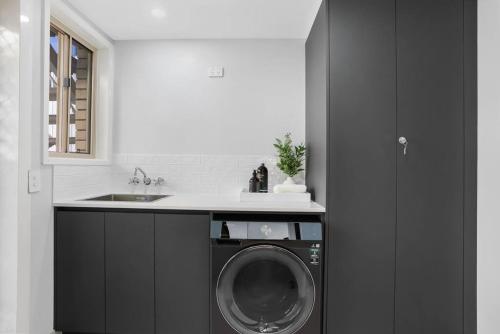 a kitchen with a washing machine and a sink at Miami Getaway in Gold Coast