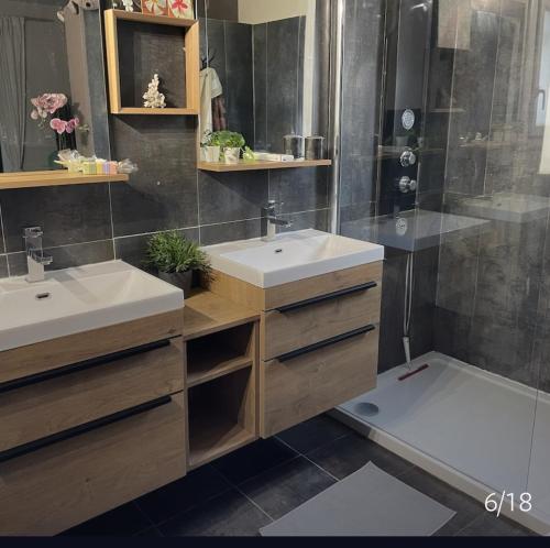 une salle de bain avec deux lavabos et une douche dans l'établissement Villa Jean Mira, à La Grande Motte