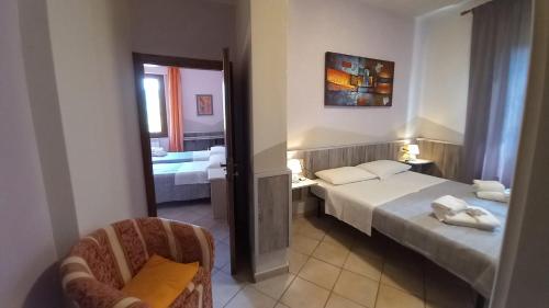 a hotel room with two beds and a chair at Hotel Le 3 Fonti in Loro Ciuffenna