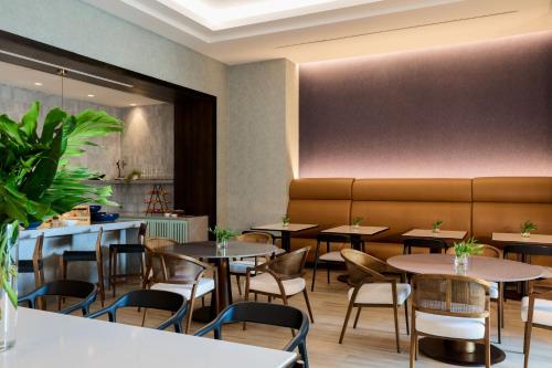 a restaurant with tables and chairs and a bench at Palmetto Marriott Resort & Spa in Palmetto