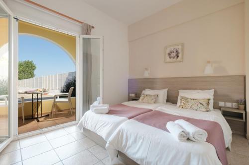 a bedroom with two beds and a balcony at Tereza Apartments in Acharavi