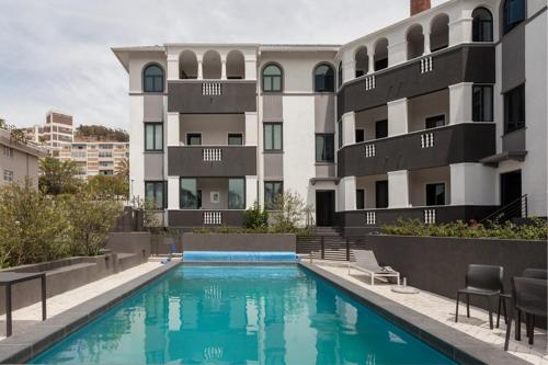 een appartementencomplex met een zwembad ervoor bij Warwick 30C in Kaapstad