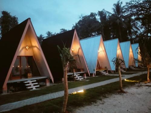 a row of cottages with blue roofs at night at Krui ocean cottage in Krui