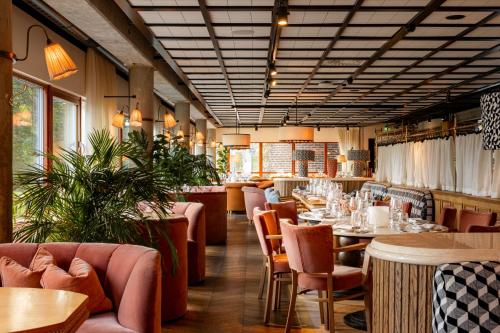 a restaurant with tables and chairs in a room at Ellery Beach House in Lidingö