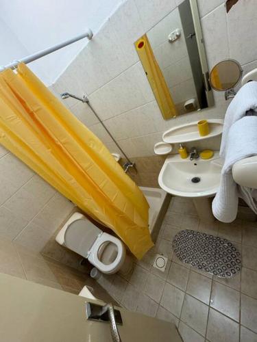 a bathroom with a yellow shower curtain and a sink at 1BR in Fujairah, CITY&SEA view in Fujairah