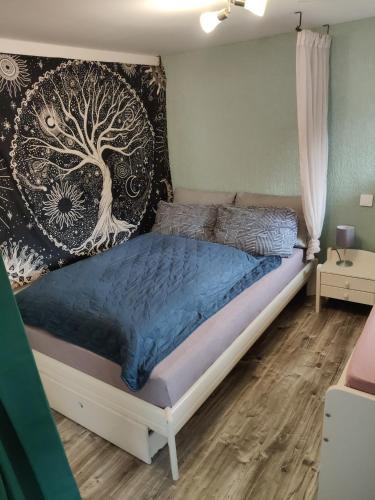 a bedroom with a bed with a tree mural on the wall at GeraldineWeg30 -FeWo Geralex in Hessisch Oldendorf