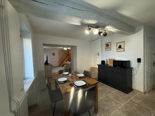 un salon avec une table et des chaises en bois dans l'établissement Meublé de Tourisme 3 étoiles La Margot, à Perrigny-lès-Dijon